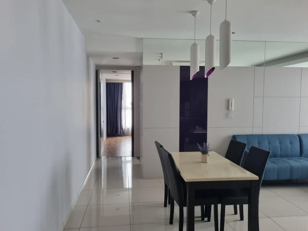 Dining features: white walls, glossy tile flooring, 4-seater dining table with marble top, black dining chairs, pendant lighting above table, decorative plant on table, mirror wall, blue fabric sofa in background, doorway leading to hallway, curtains in doorway; style: modern. Room features: white walls, wood flooring, doorway leading to another room, curtains.